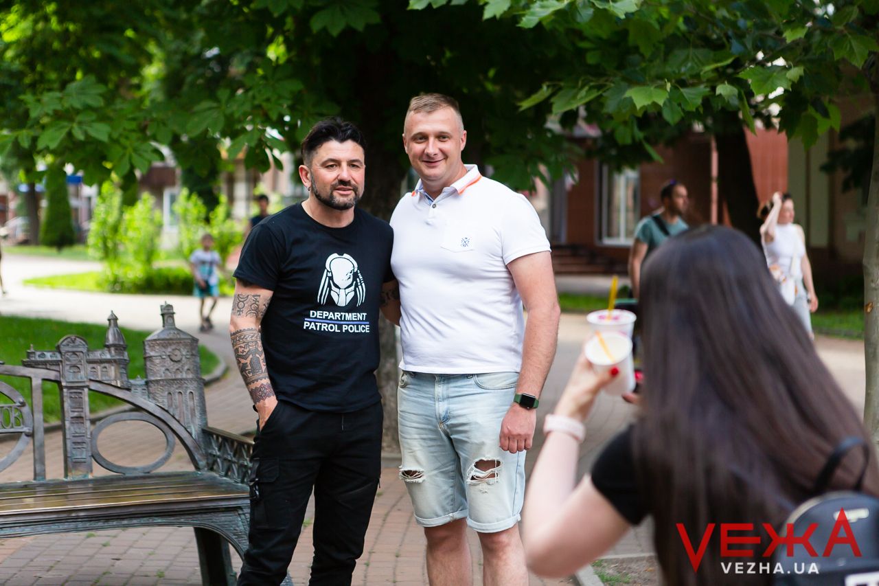 Three people posing for a casual outdoor photo on a sunny day.