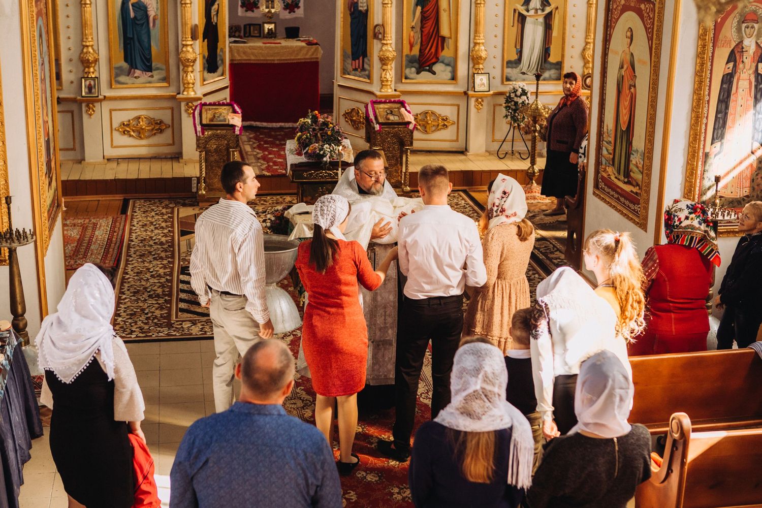 Orthodox church interior with congregation gathered for religious ceremony.
