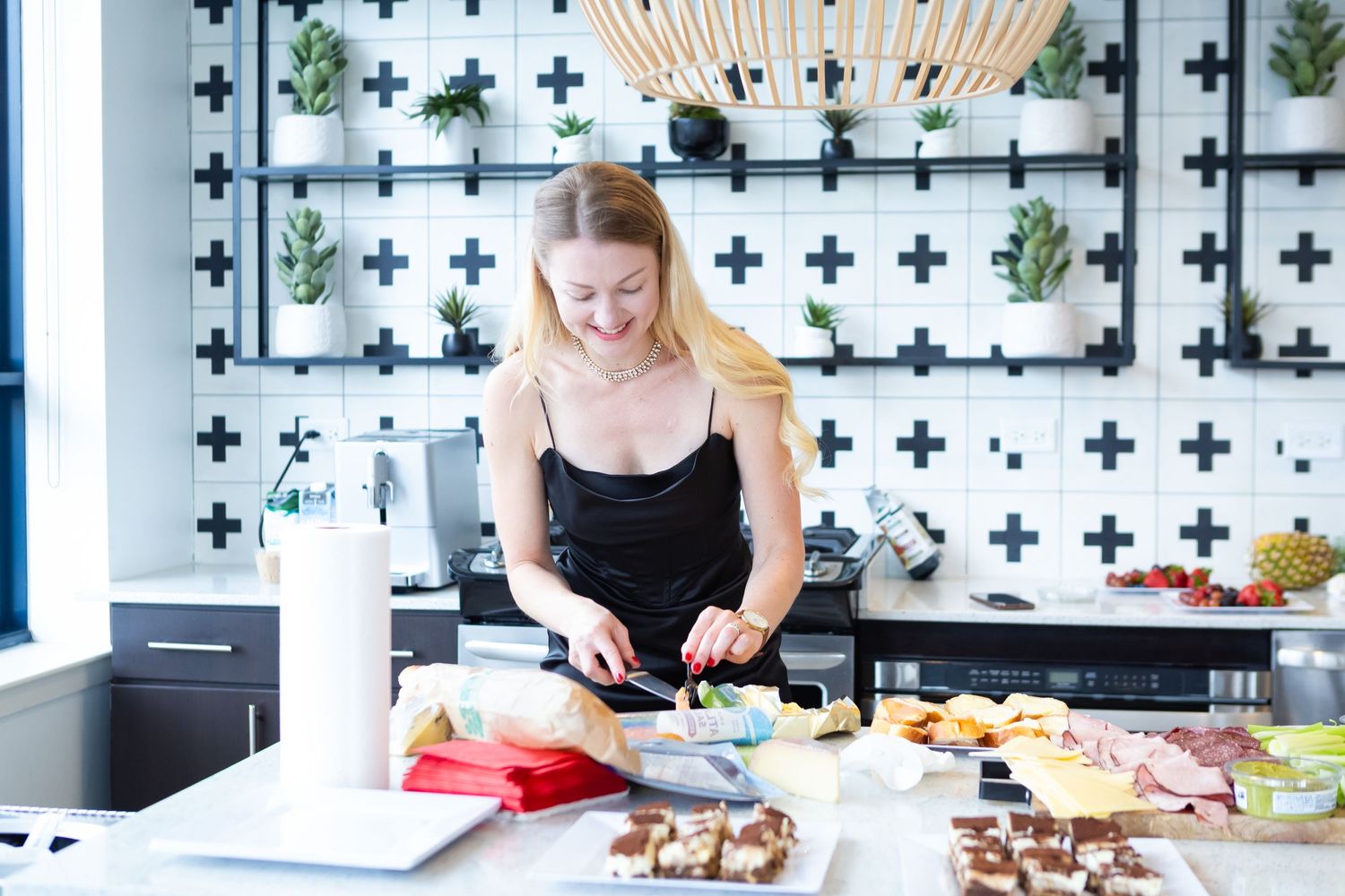 Chef preparing ingredients on cutting board in modern kitchen with geometric wall decor.