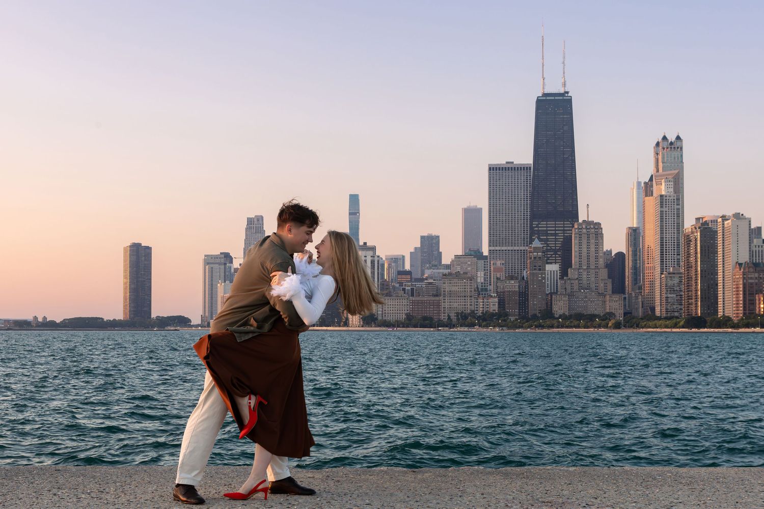 Chicago skyline at sunset with Lake Michigan in the foreground, creating a stunning urban waterfront panorama.