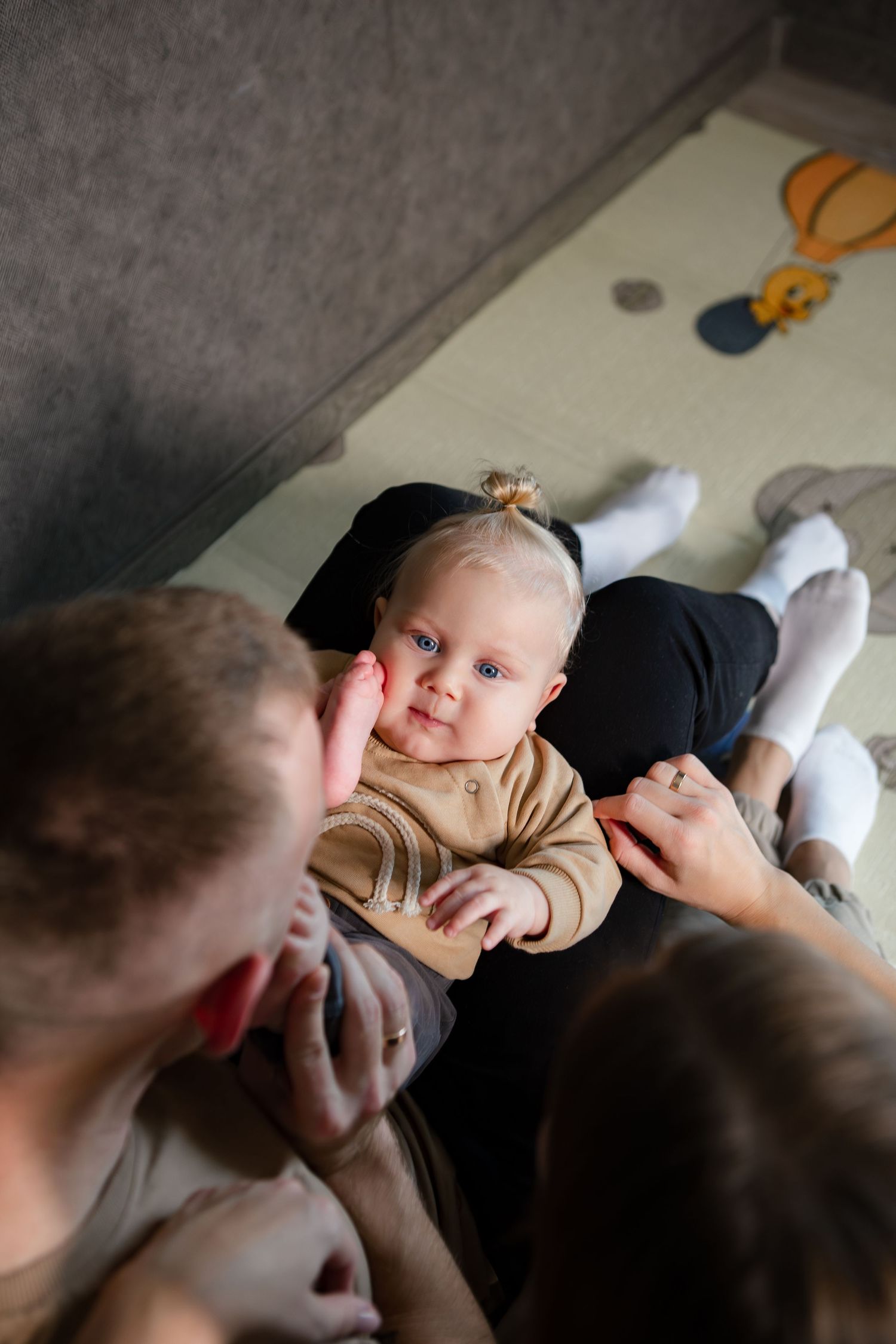 A sequence of candid photos showing tender moments between a baby and parent lying down together.