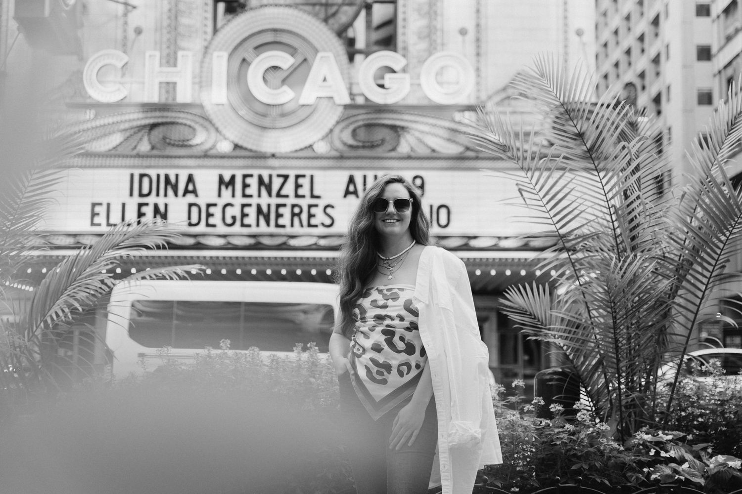 Black and white portrait in front of historic Chicago Theater marquee.
