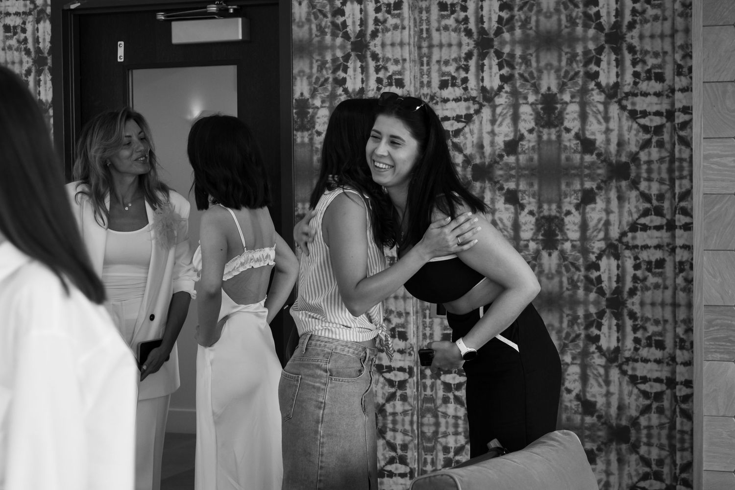 Group of women socializing at casual gathering in black and white.