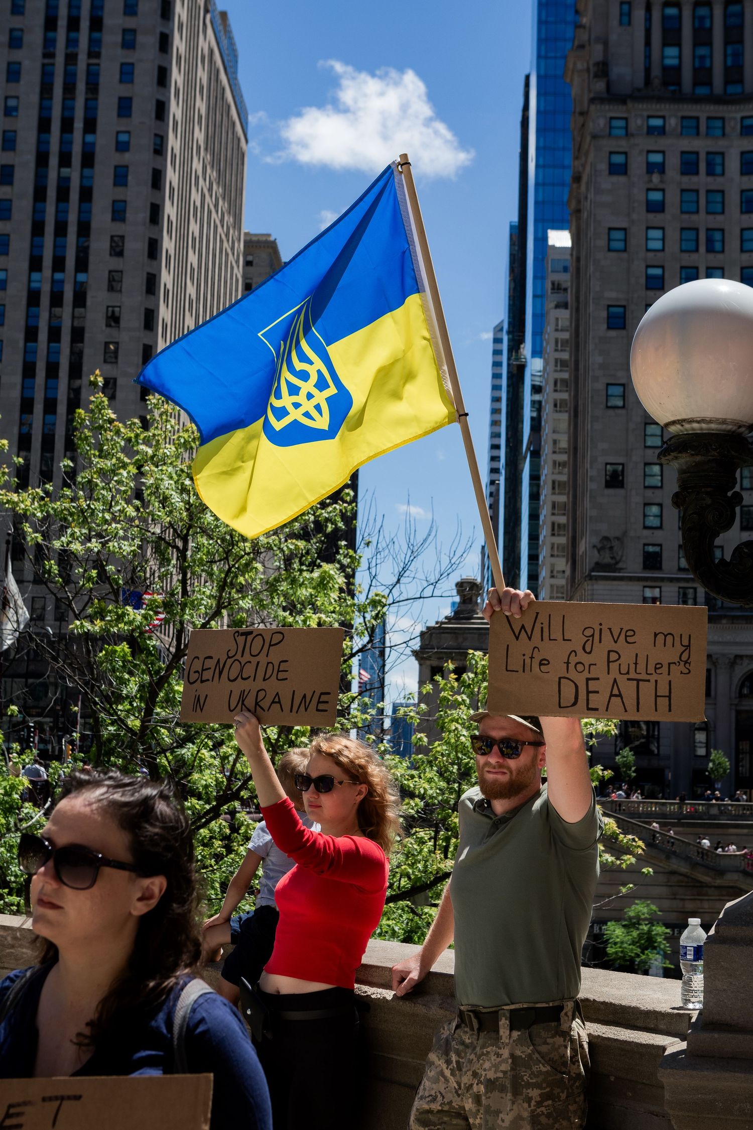 Protesters wave Ukrainian flags and hold signs during a rally in downtown Chicago.