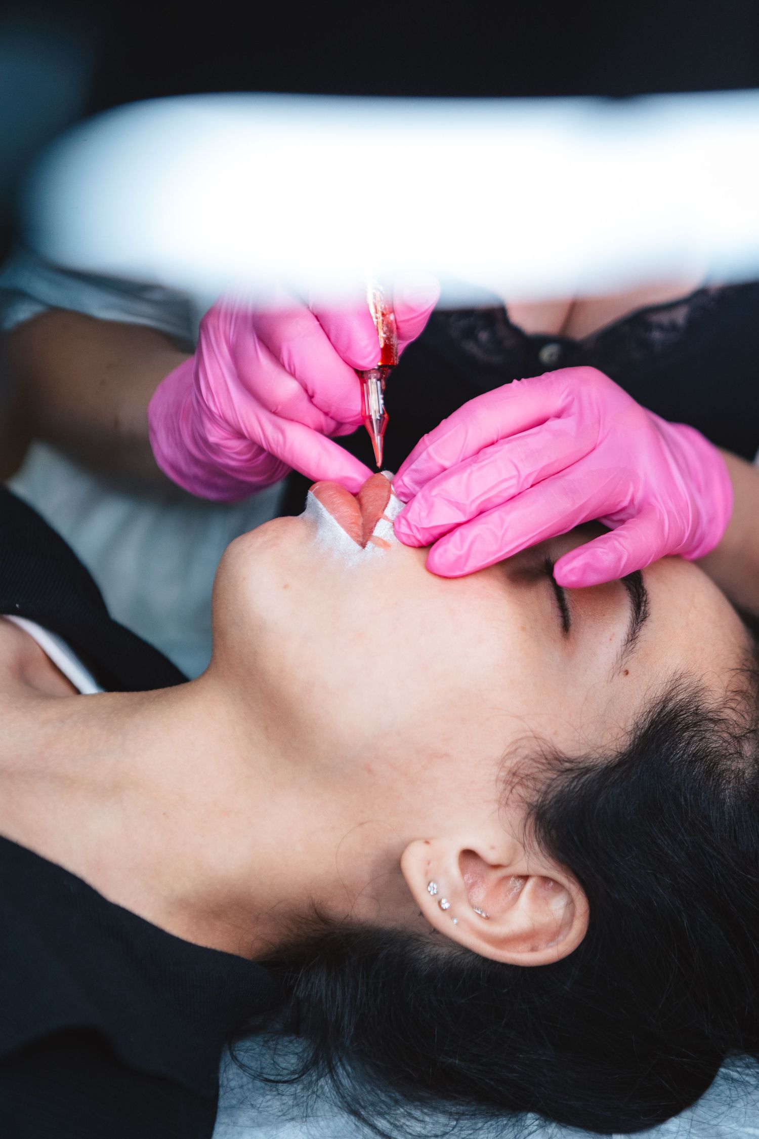 Close-up shot of a dental procedure being performed with bright pink medical gloves.