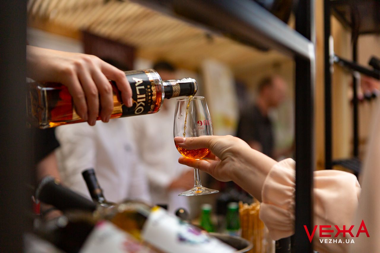 Pouring wine into glass at tasting event shown in closeup.
