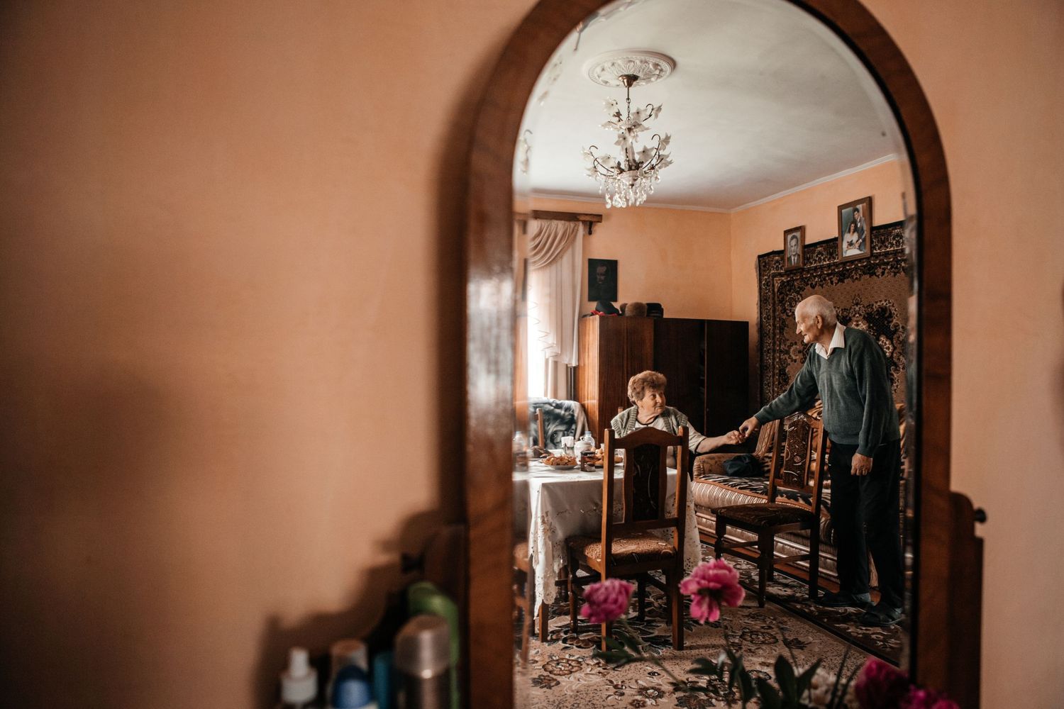 View through an arched doorway into a room with vintage furniture and decor.