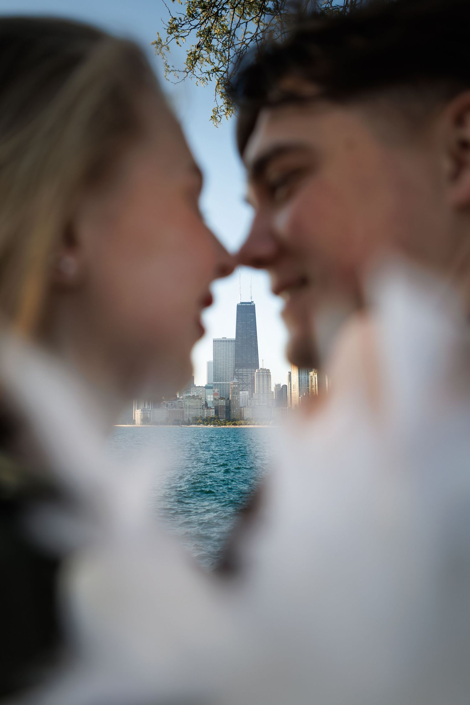 A romantic couple shares a tender moment with Dubai's iconic skyline and waterfront visible in the background.