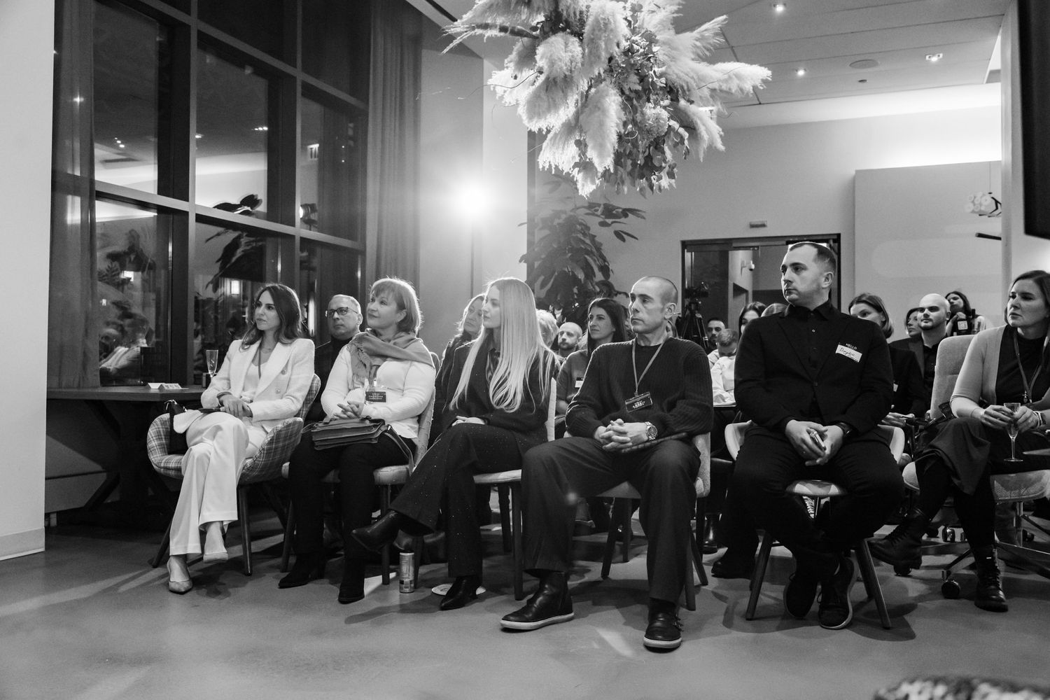 Black and white photo of audience members seated in rows at indoor event venue.