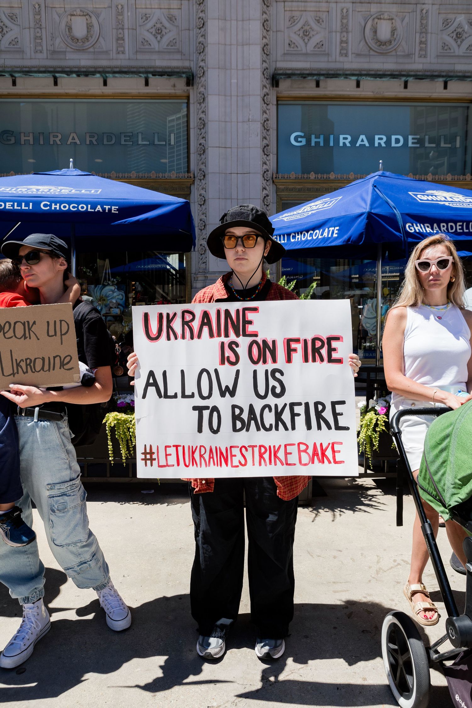Protesters with signs outside Ghirardelli store advocate for Ukraine with Let Ukraine Strike Back message.