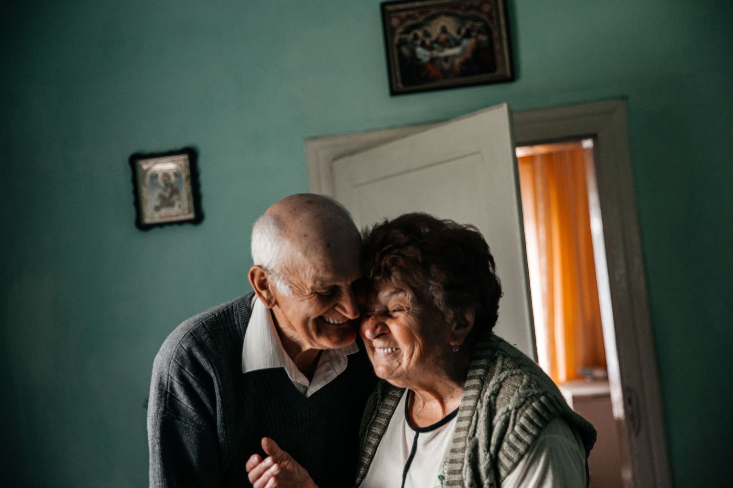 Intimate moment shared in a room with turquoise walls and warm lighting.