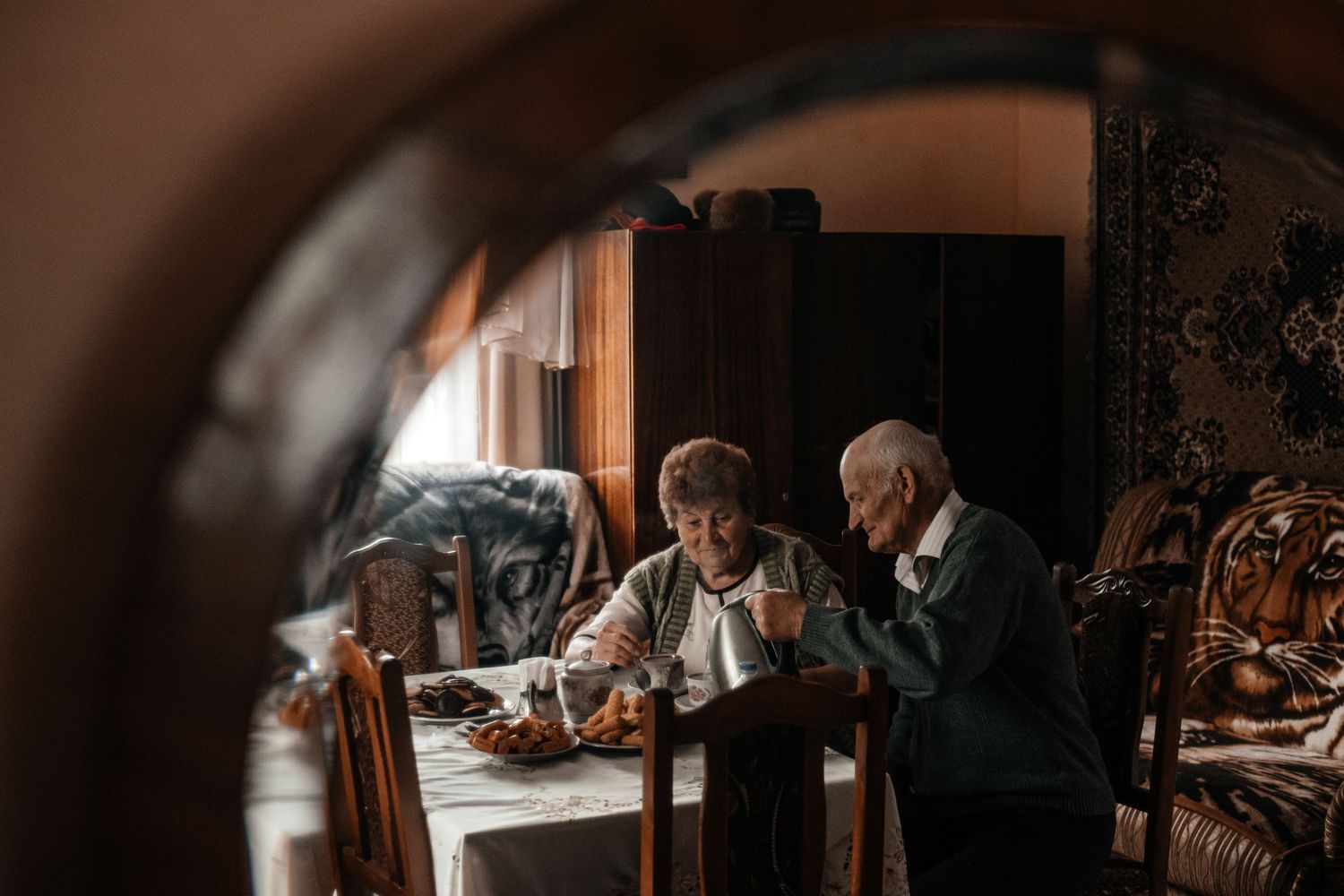 Two people sharing a meal at an ornate wooden dining table.
