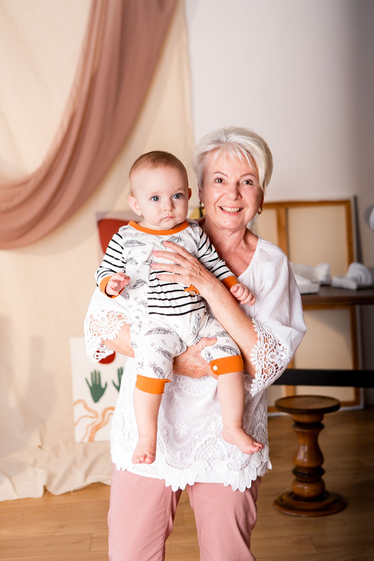 A small child in striped clothing being held and embraced in a bright interior setting.