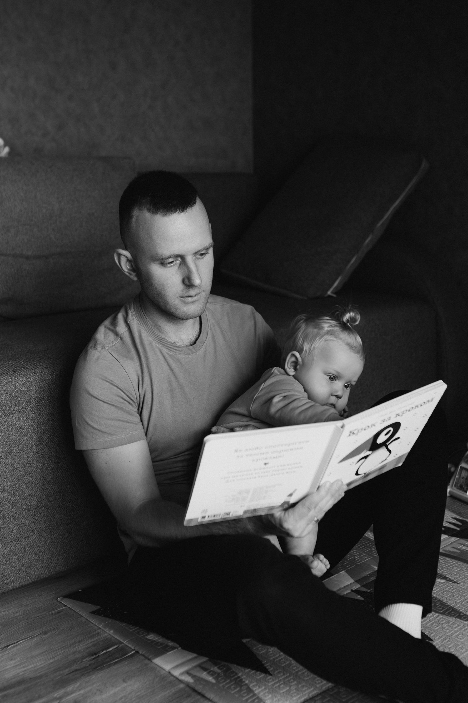 A series of black and white photos showing someone reading a book in dim lighting at different angles.