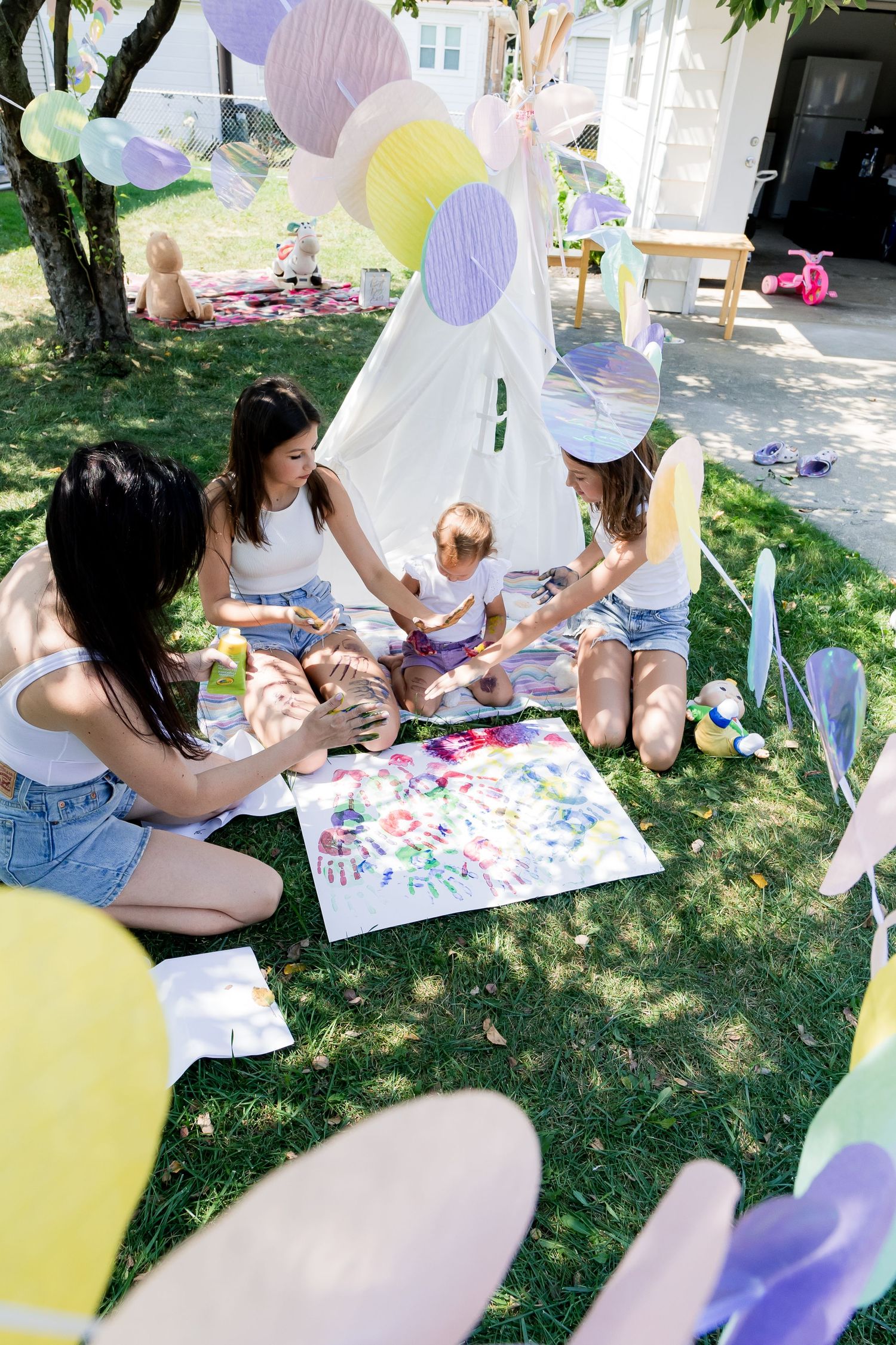 Outdoor art session with colorful decorations and white fabric creating a festive atmosphere.