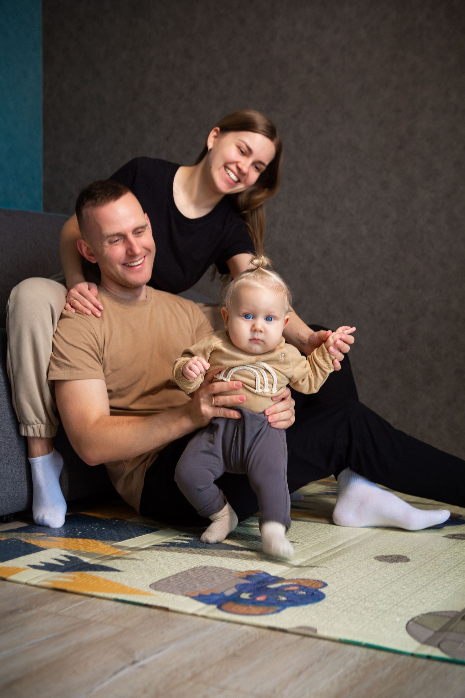 Family plays together on a soft mat while enjoying quality time at home.