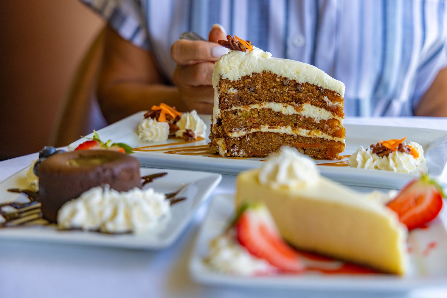 Someone is holding a fork taking a scoop out of a carrot cake