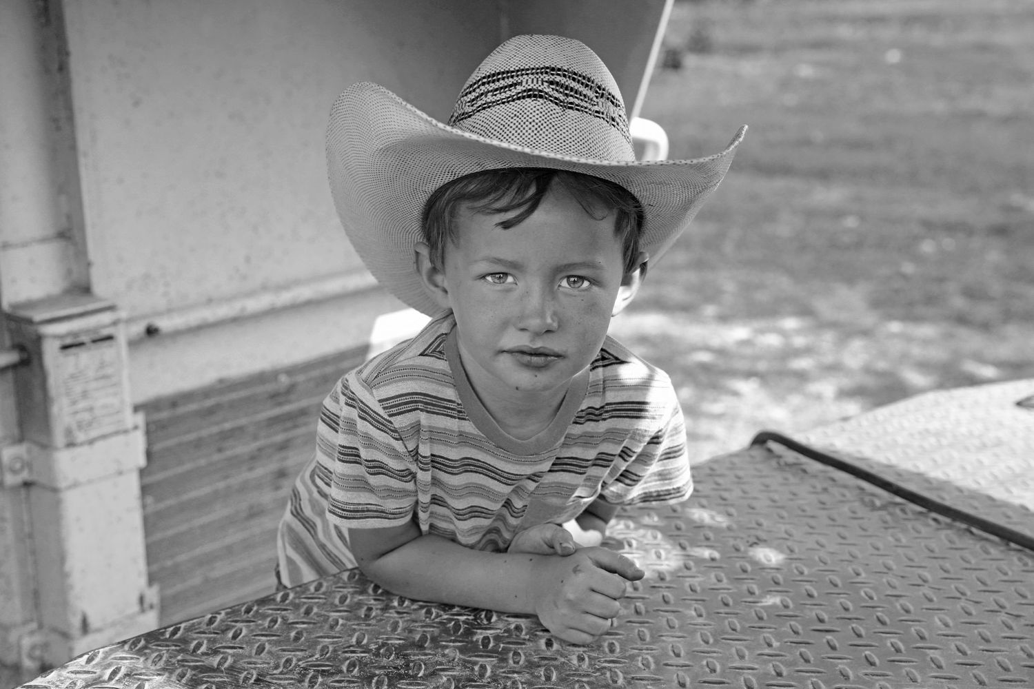 Little boy wearing a striped shirt and cowboy hat