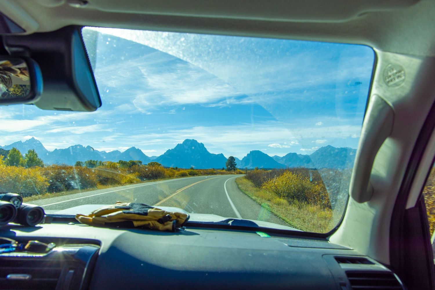 Mountain landscapes shown through a front window of a moving vehicle