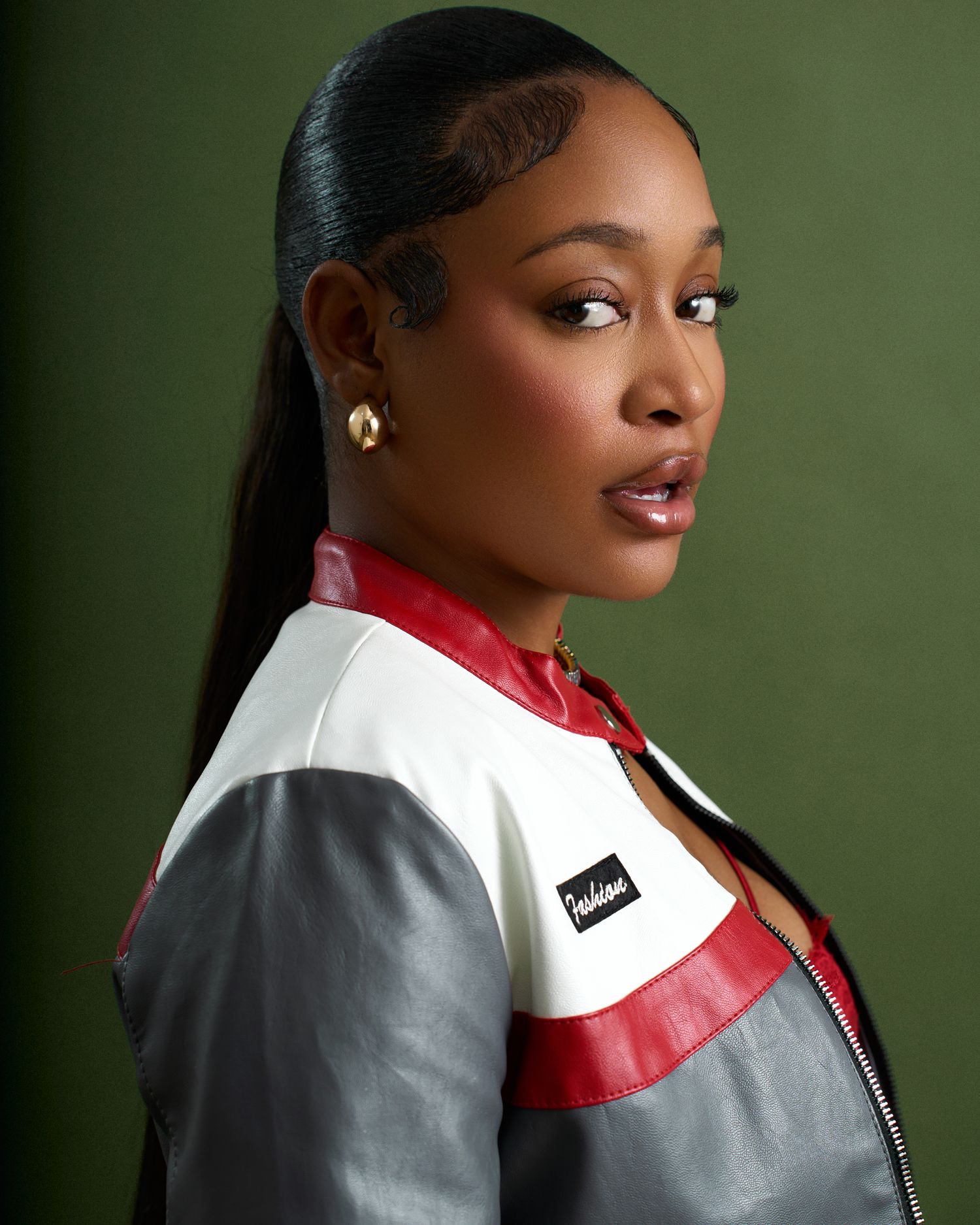 Fashion portrait series featuring grey and red color-blocked jacket styling against green backdrop.