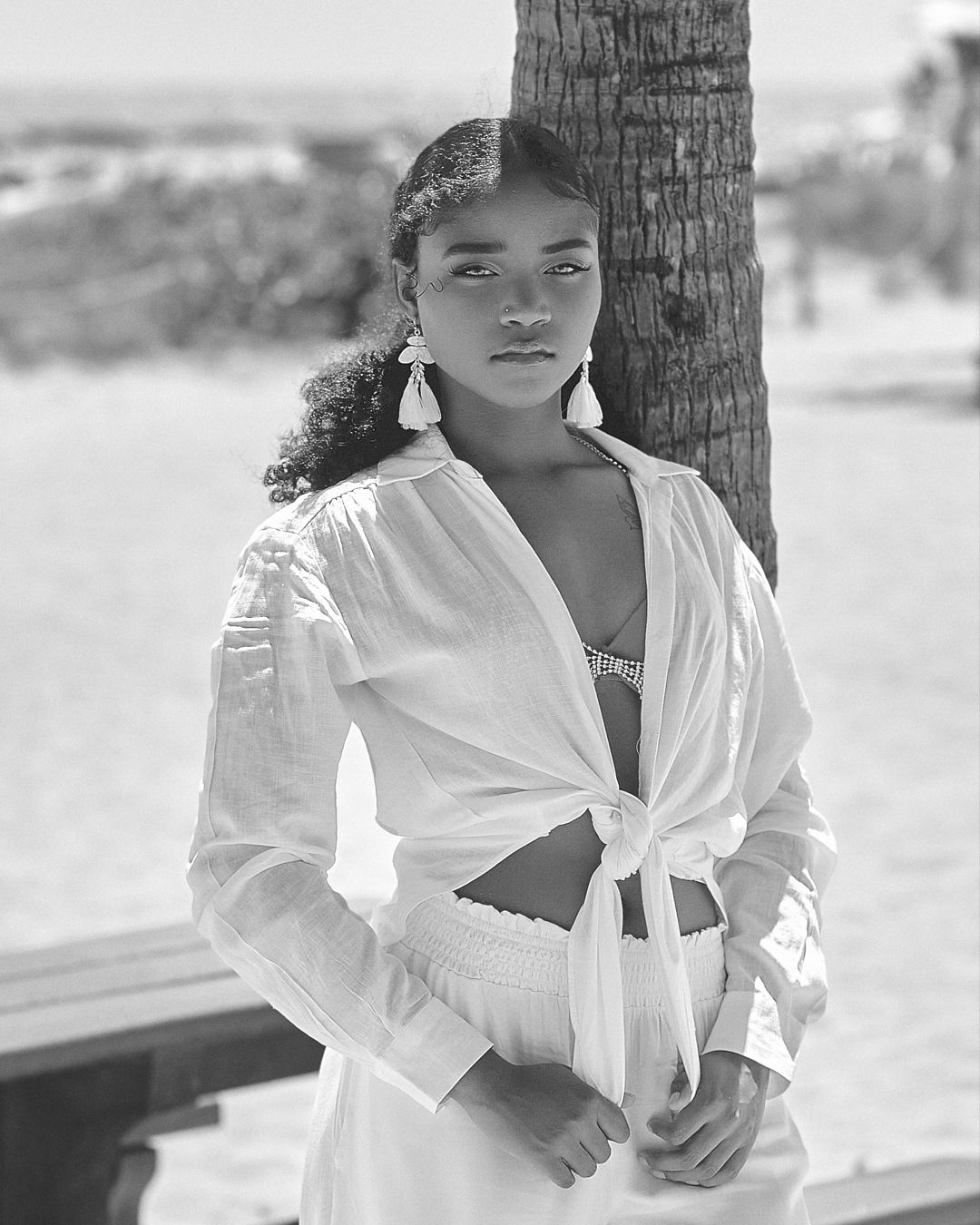 Black and white beach portrait with palm tree shadows.