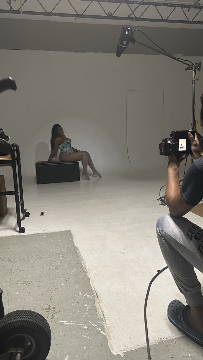 Professional photo studio setup with lighting equipment and camera gear during a fashion shoot.