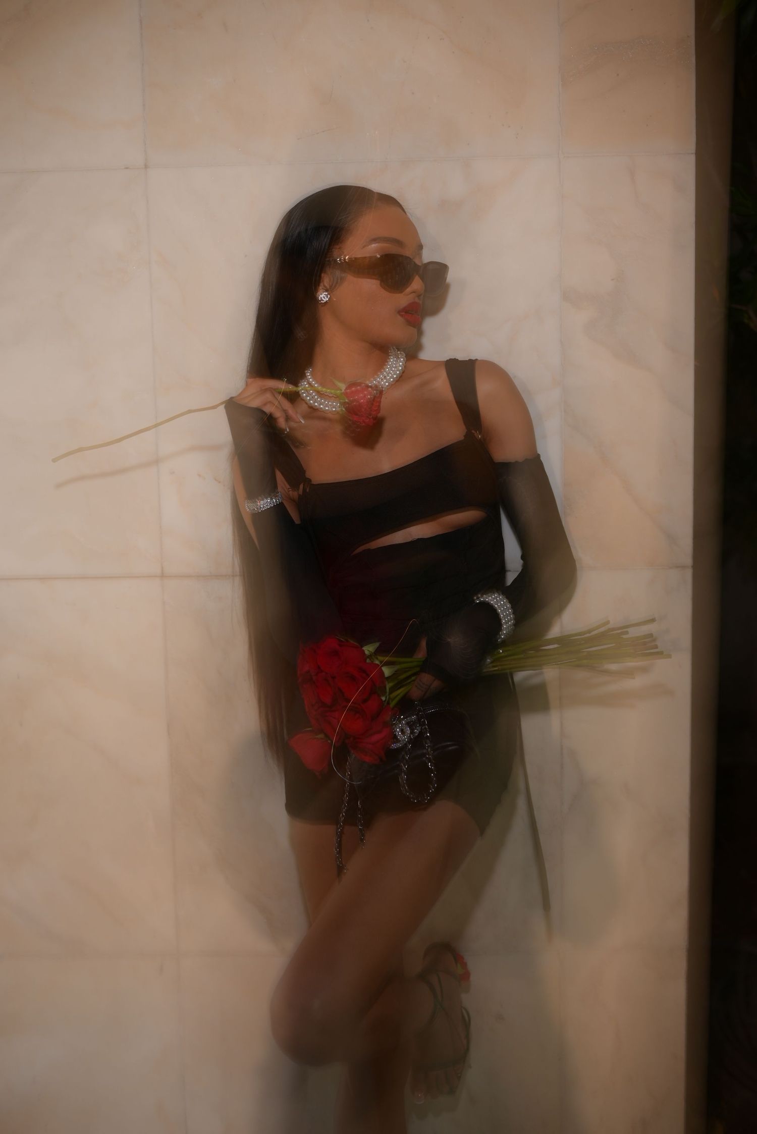 Dreamy motion blur photograph showing black dress and red floral elements.