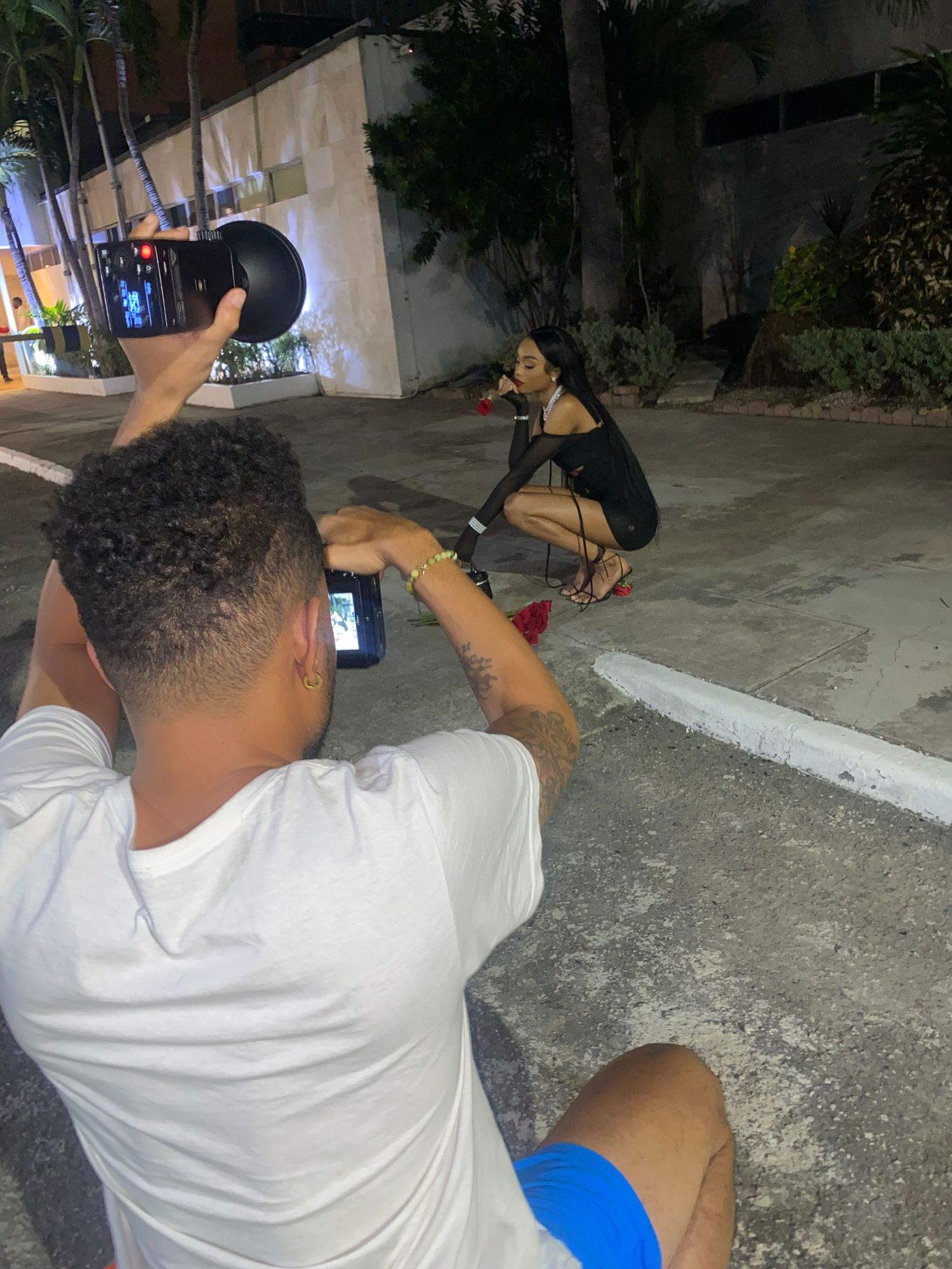 Behind-the-scenes photo shoot setup with photographers working on a nighttime outdoor location.