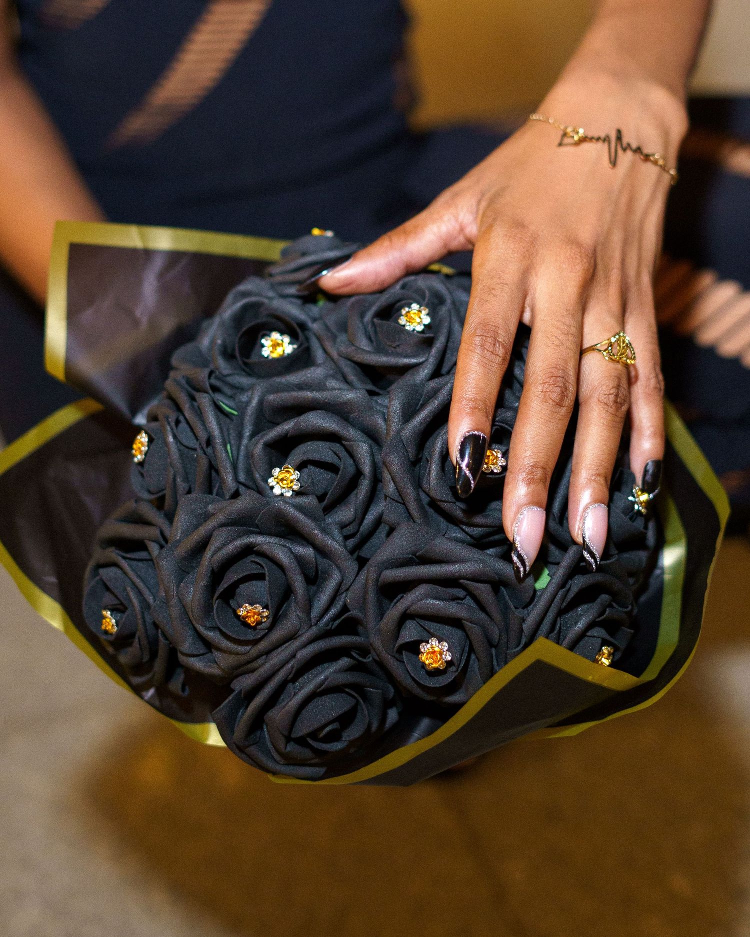 Close-up of black floral handbag with decorative details.