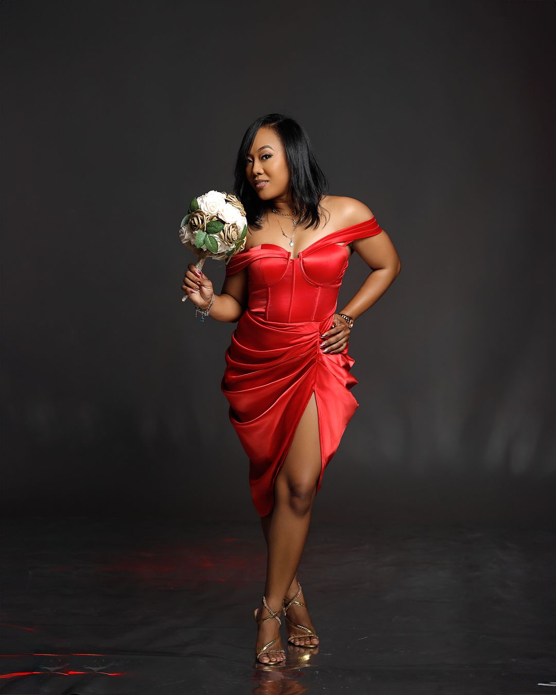 Artistic fashion series with model in red dress against dark studio setting.