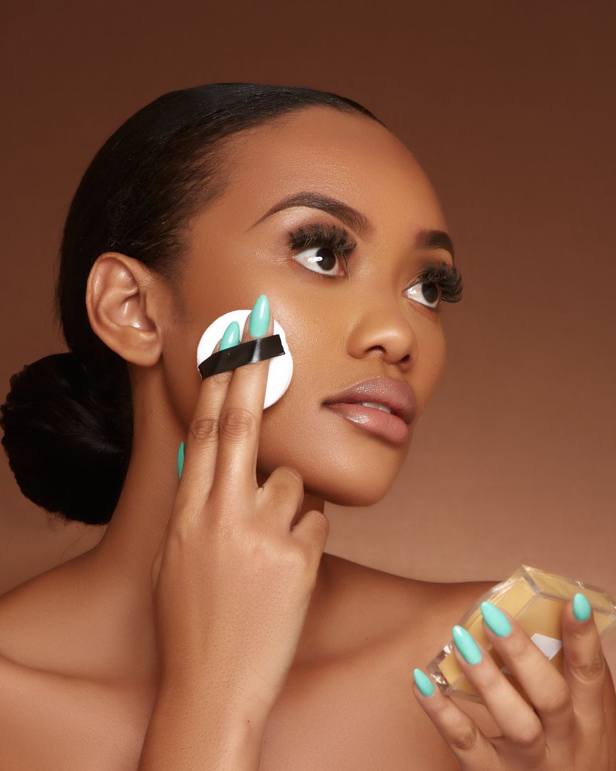 Beauty product advertisement showing hands applying skincare with turquoise nail polish.