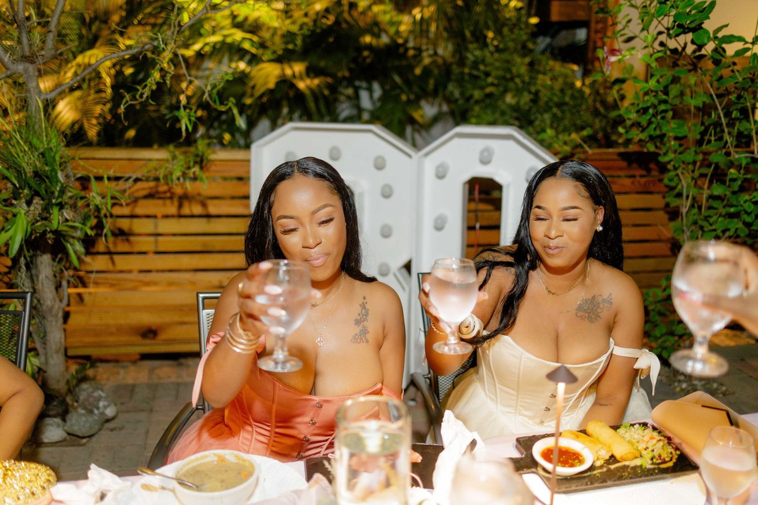 Group dining together at an outdoor restaurant table with decorative lighting.