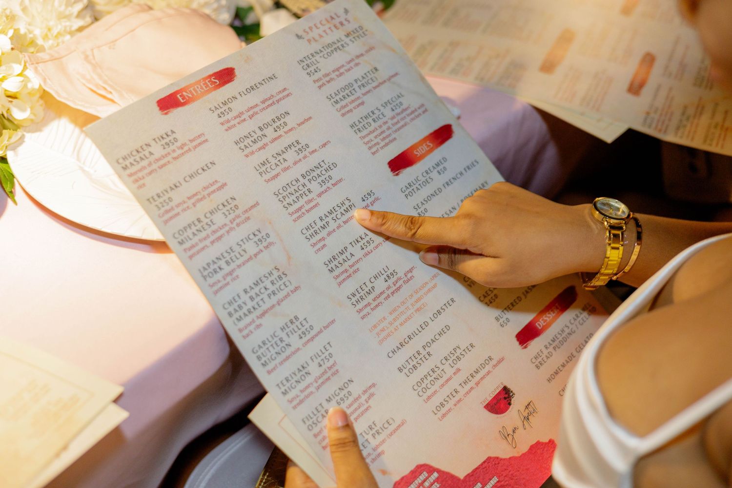 Close-up of hands holding restaurant menu during dinner.