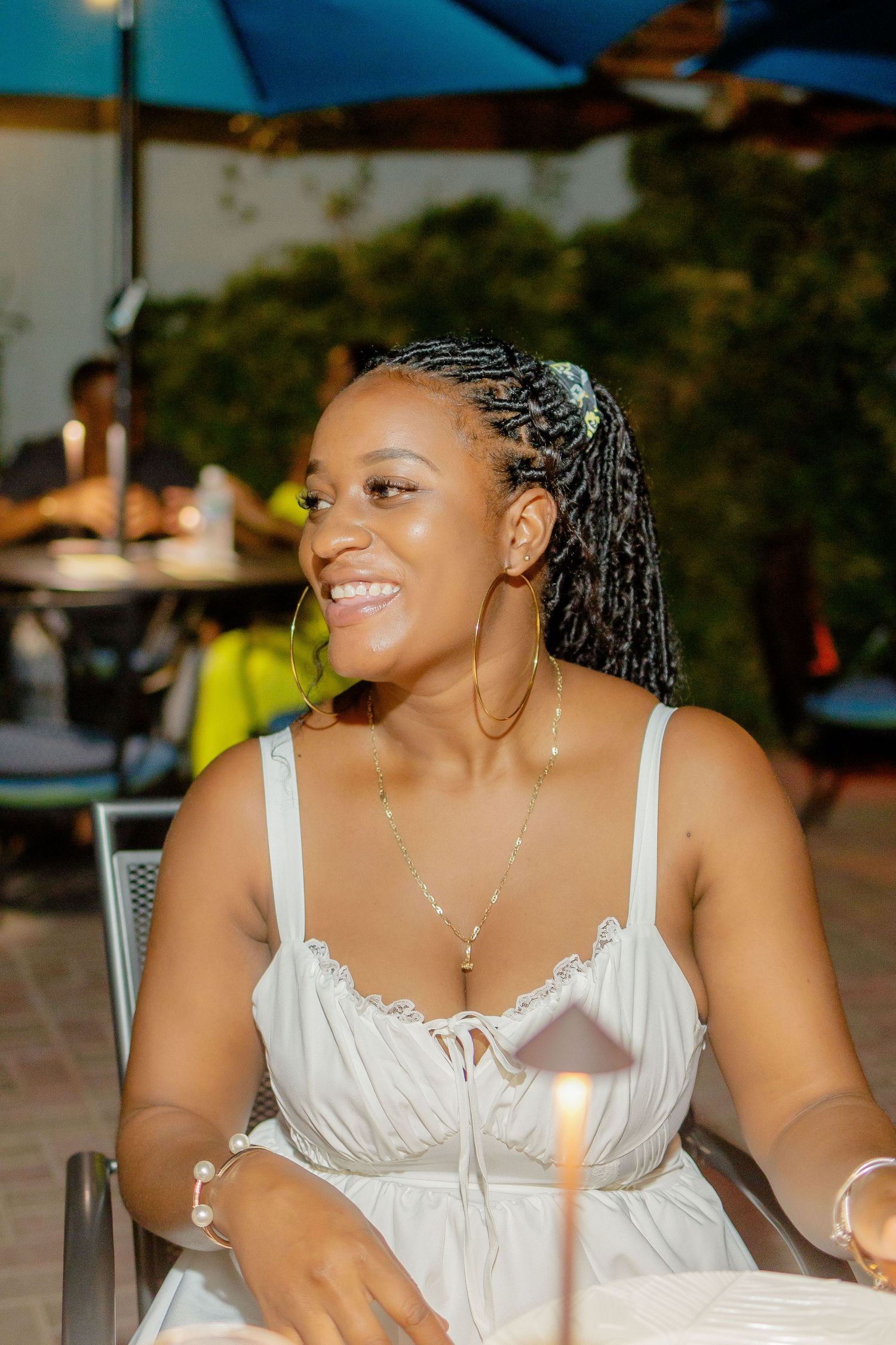 Woman in white dress smiling and enjoying an outdoor evening event at Coppers.