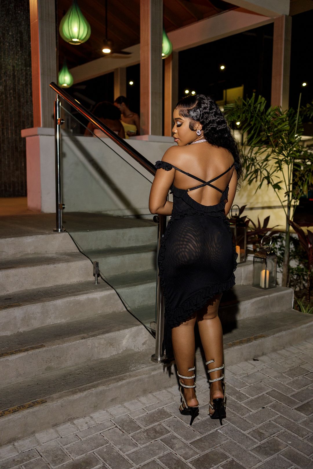 Artistic nighttime photo series showing poses near green lanterns and stone pavement.