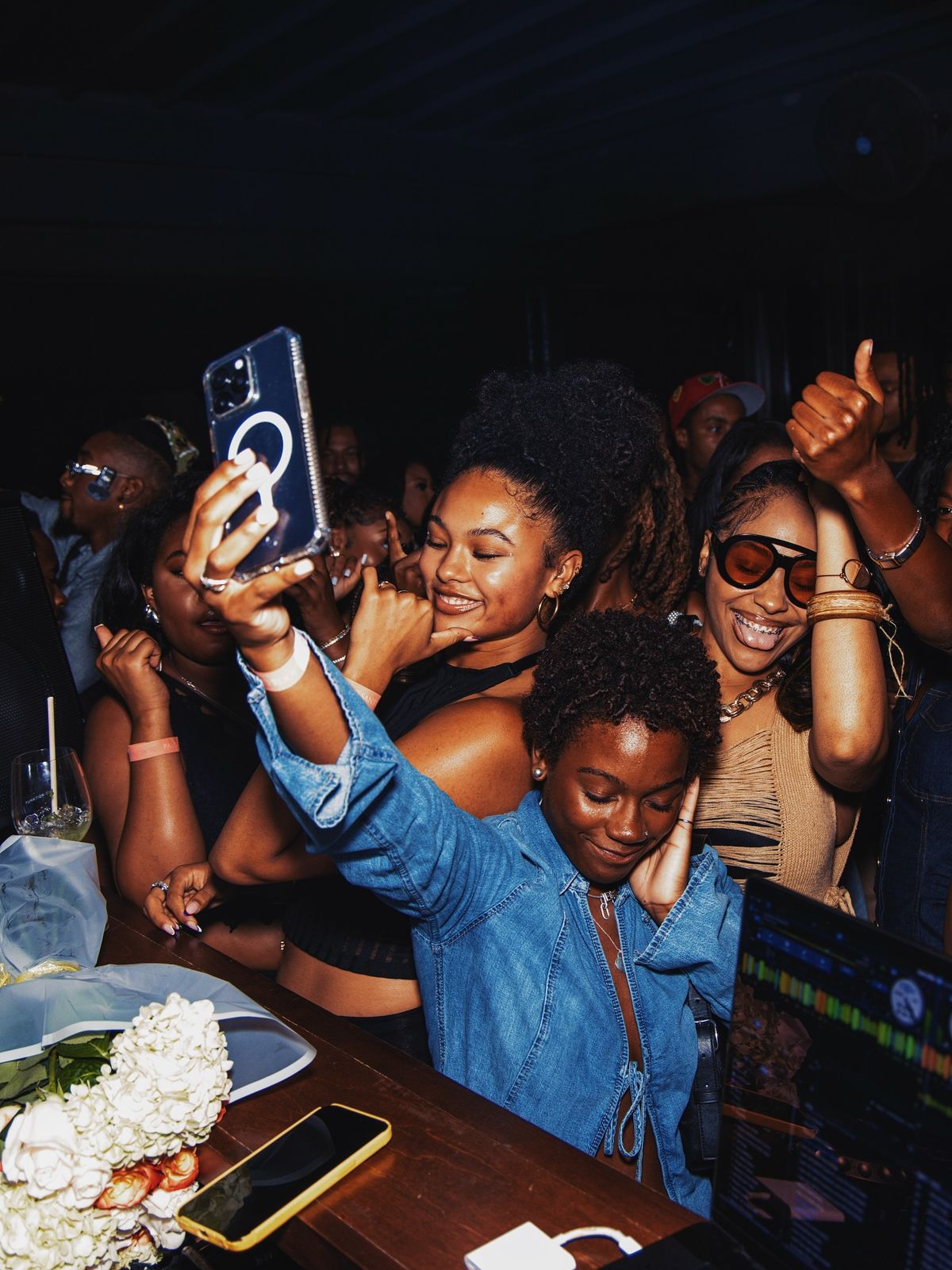 Group of young women taking a selfie and celebrating at a nightclub party event.