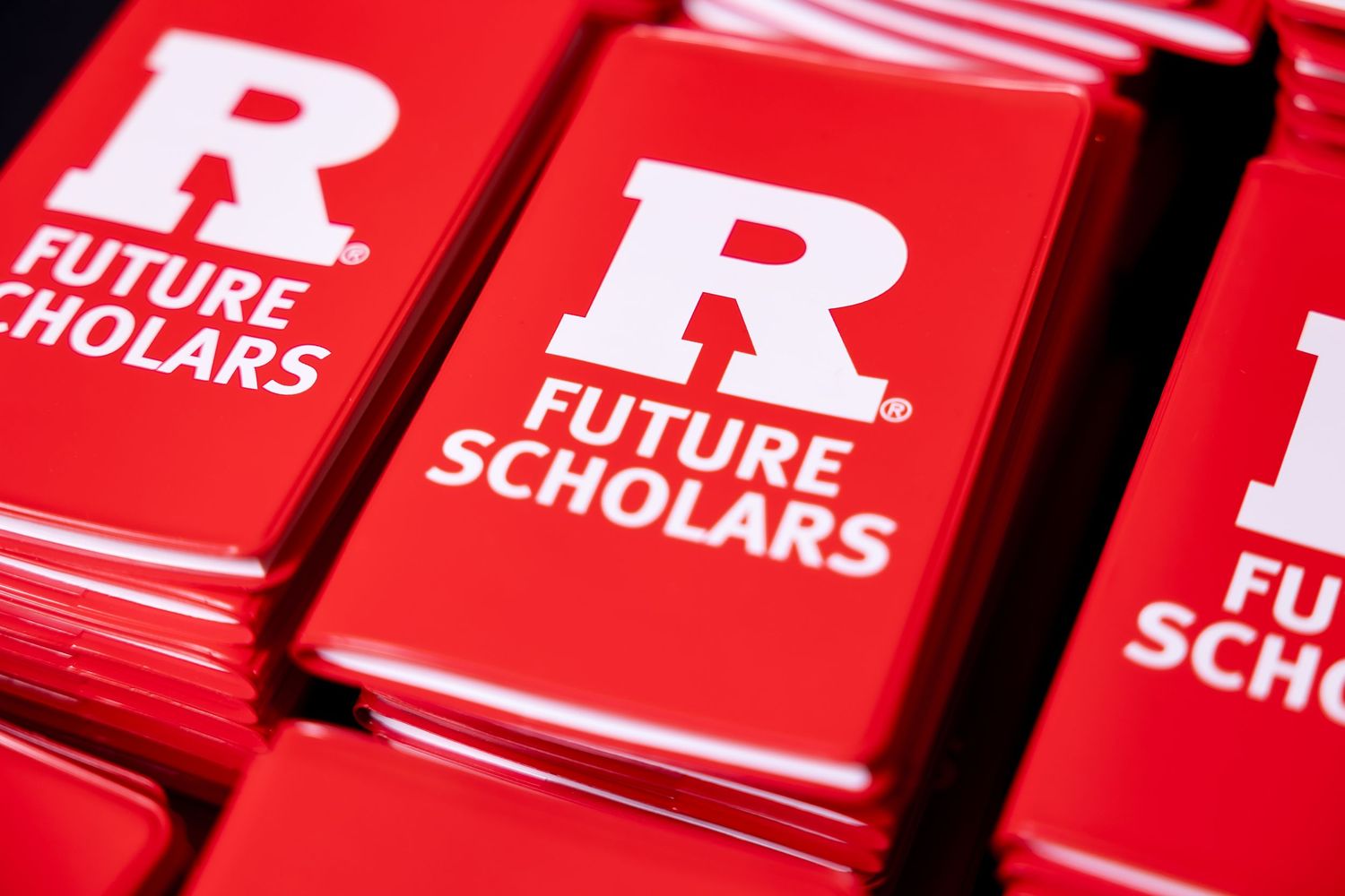 Row of bright red Rutgers branded folders or materials lined up in sequence.
