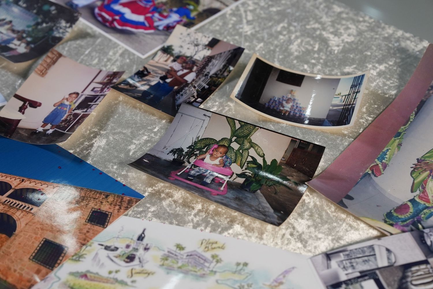 A scattered collection of old family photographs and postcards spread across a table, capturing cherished memories.