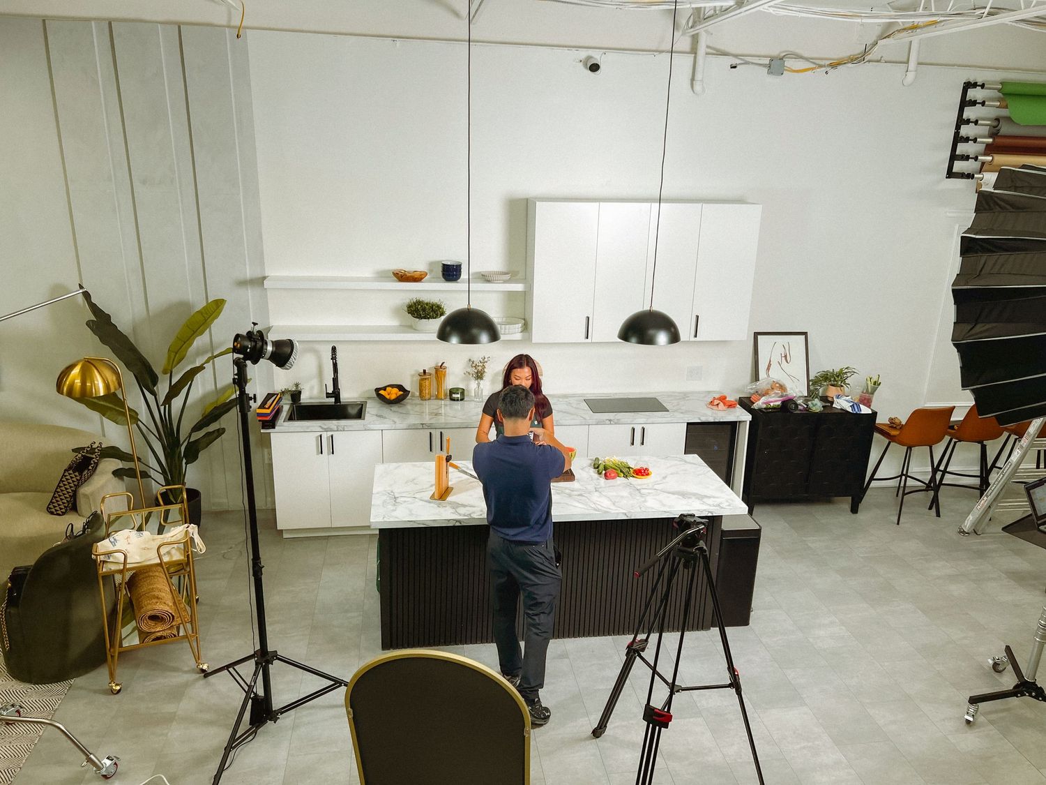 Professional photography setup in modern kitchen studio with lighting equipment.