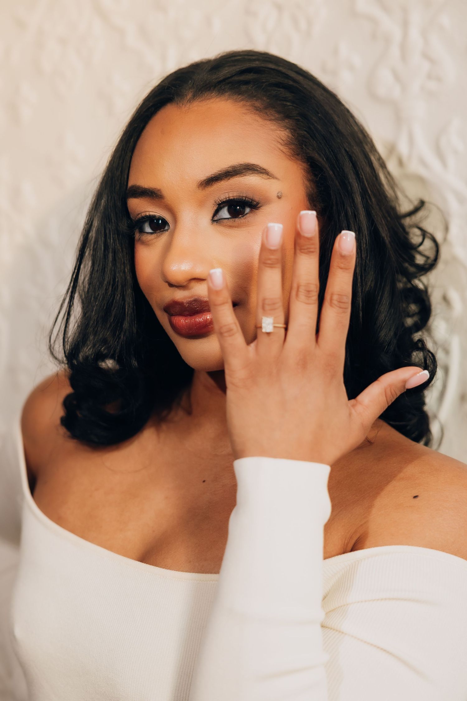 A series of artistic self portraits showing someone wearing a white top posing with their hand covering part of their face.