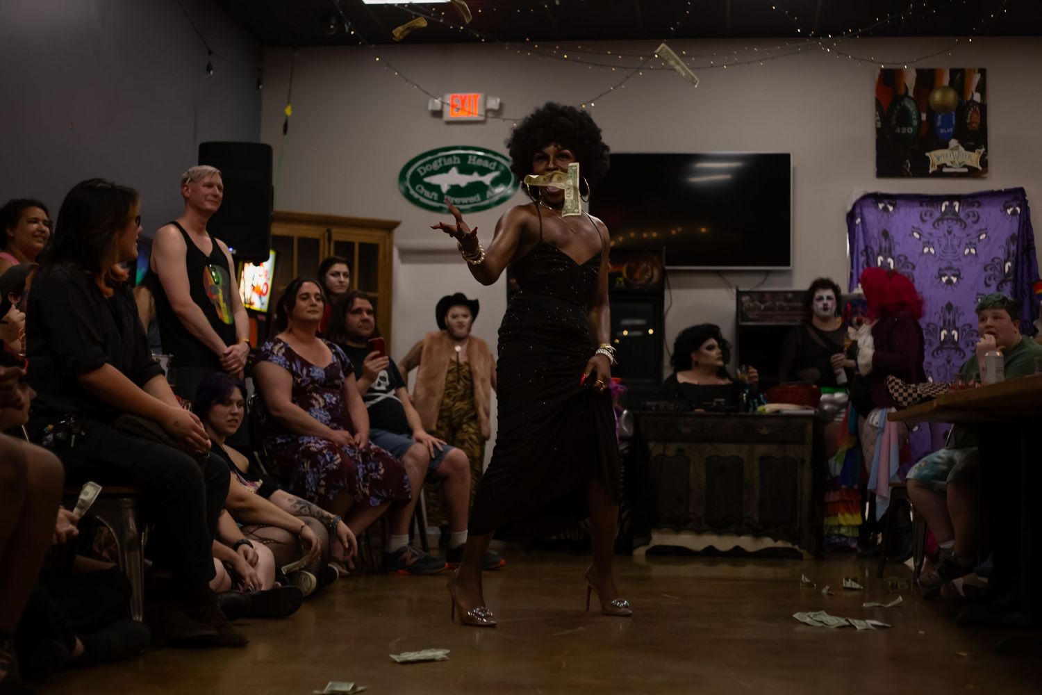 Drag performer entertaining a crowd at an indoor venue during a lively drag show performance.