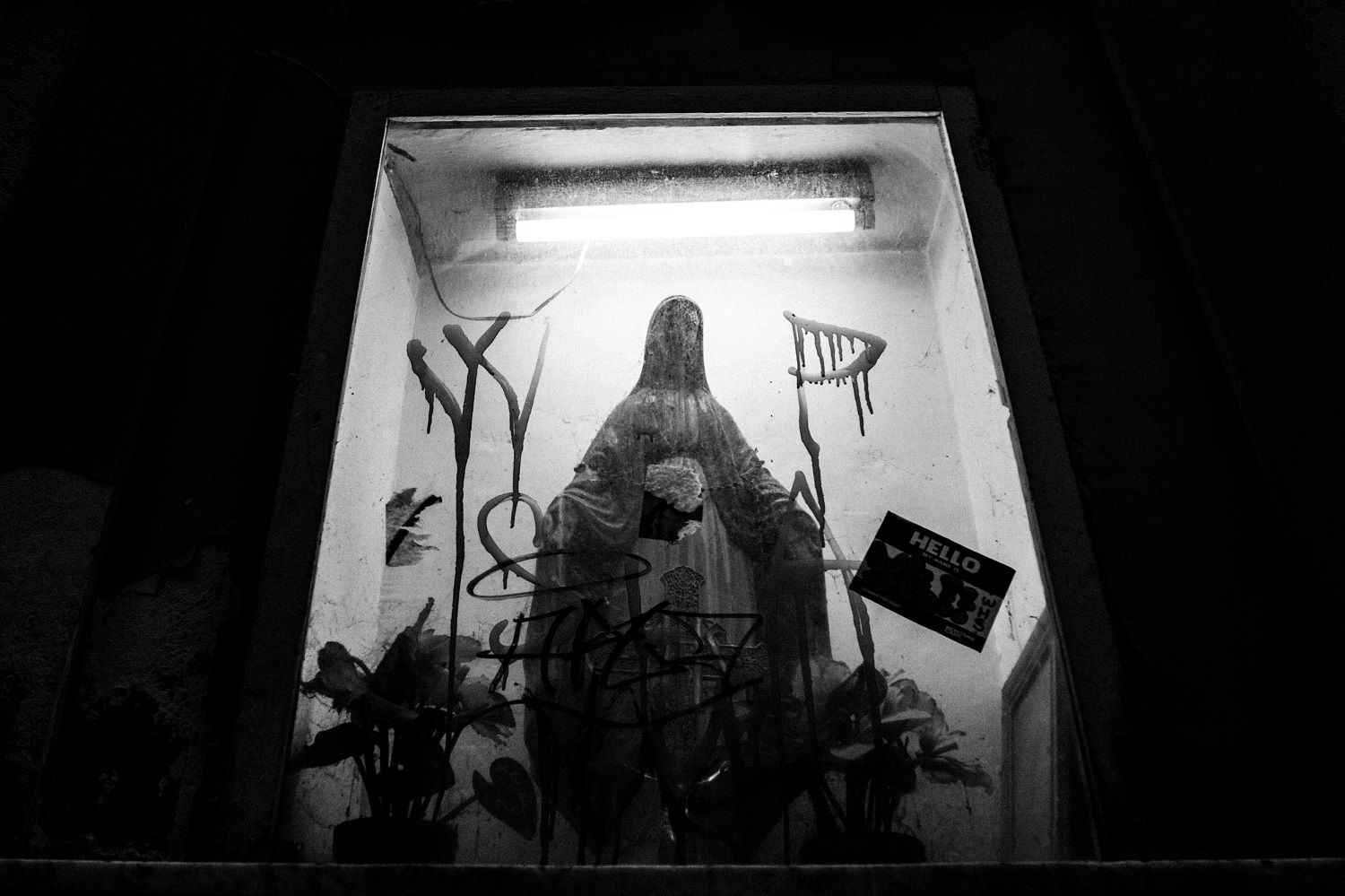 traditional Madonna covered in modern graffiti: street art juxtaposition in Naples, Italy
