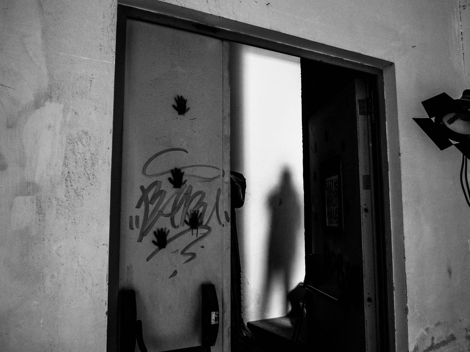 abstract photography with an human shadow, a door and fingerprints in Corviale, Rome