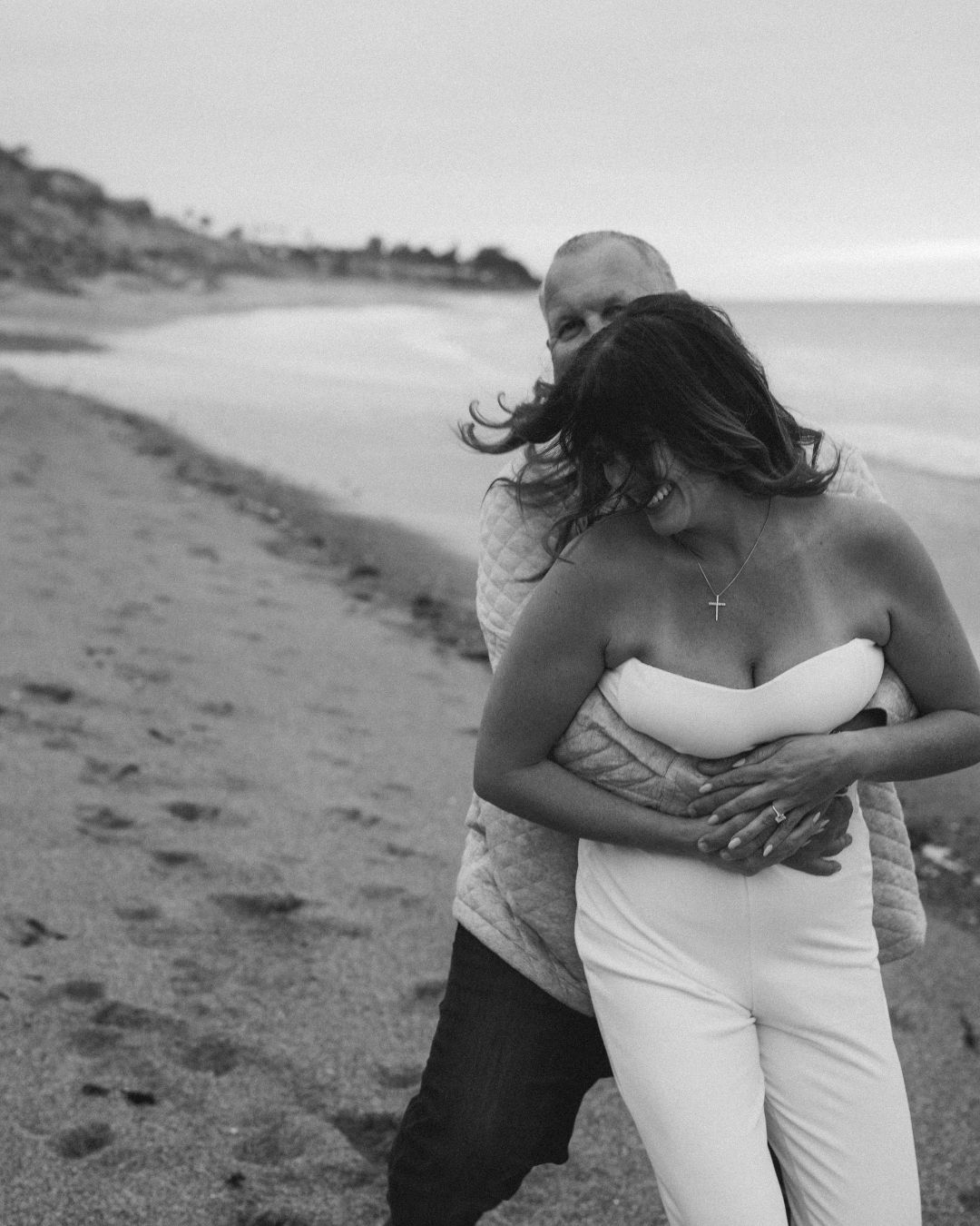 Candid moment captured during a couples portrait session at the beach in Orange County by Makenzie Rae Photography