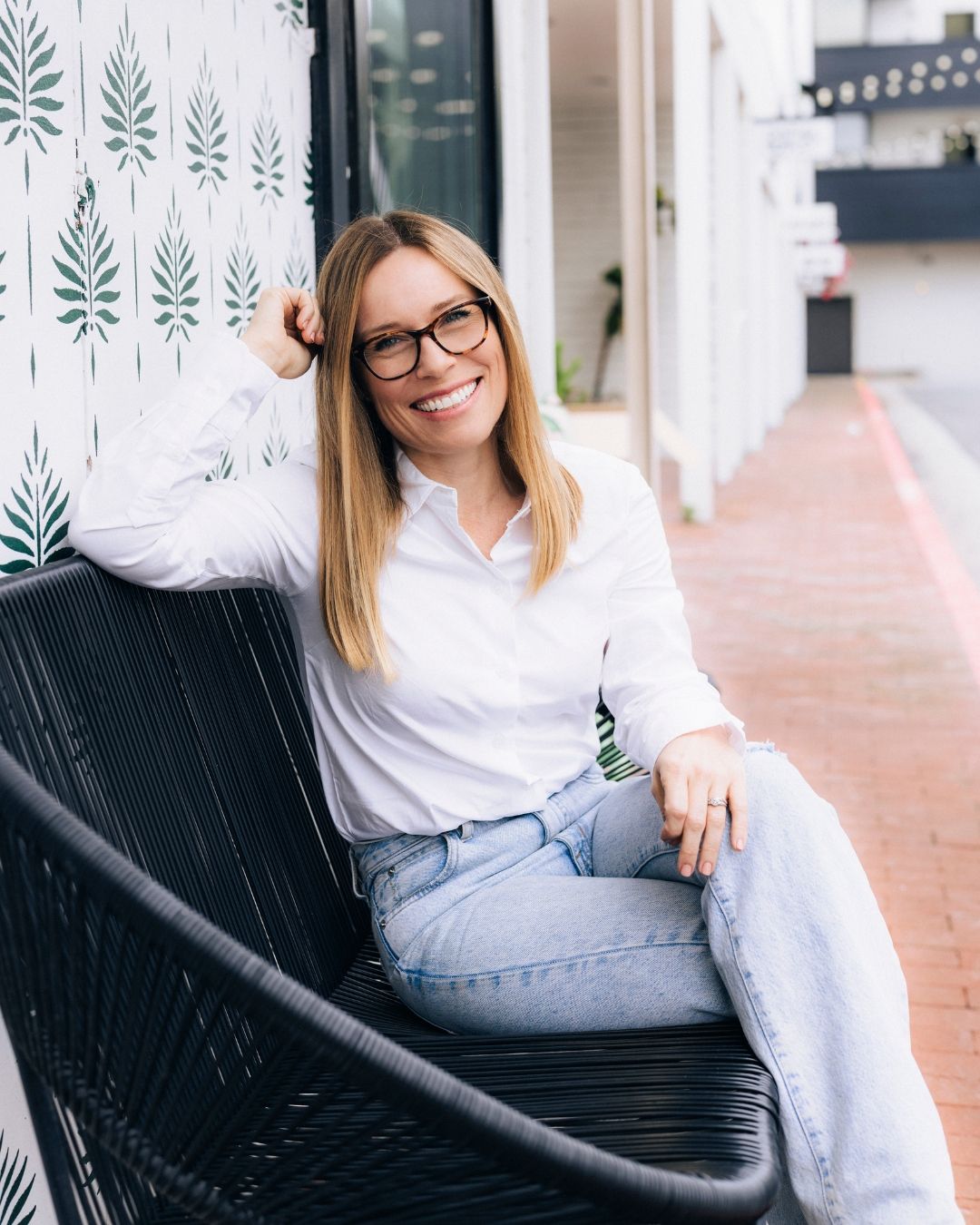 Professional headshot of a woman in a modern white interior, Orange County headshot photography by Makenzie Rae Photography.