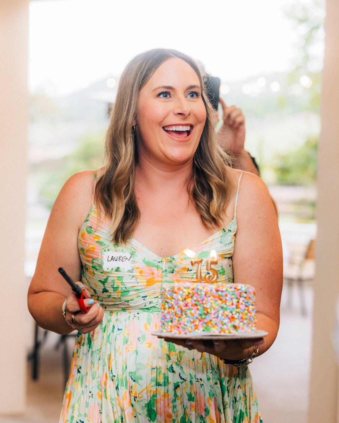 Woman in a floral dress celebrating at an Orange County event, photographed by Makenzie Rae Photography, Orange County California event phot