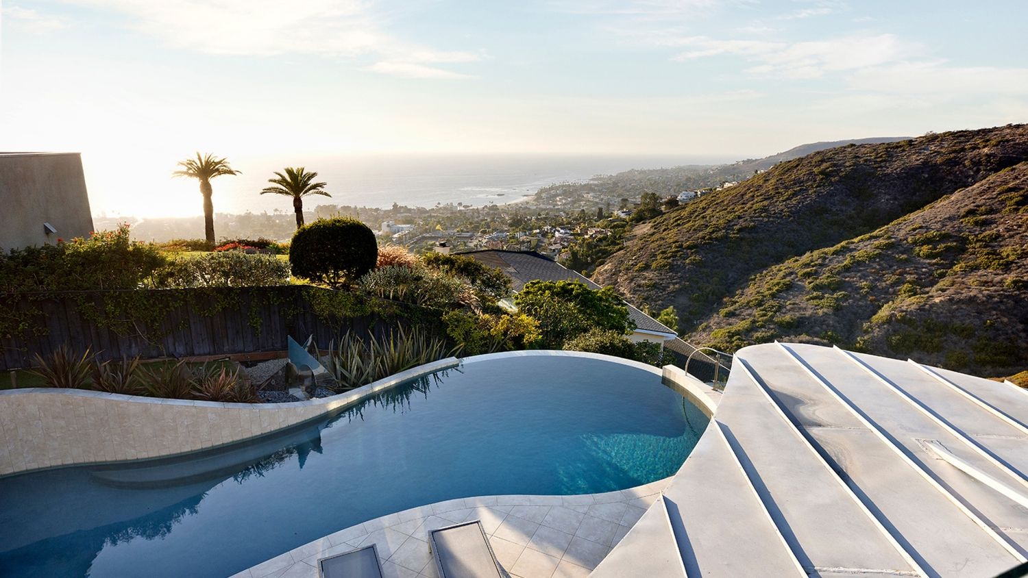Luxury home exterior with pool at sunset, real estate photography by Makenzie Rae Photography, Laguna Beach California photographer.