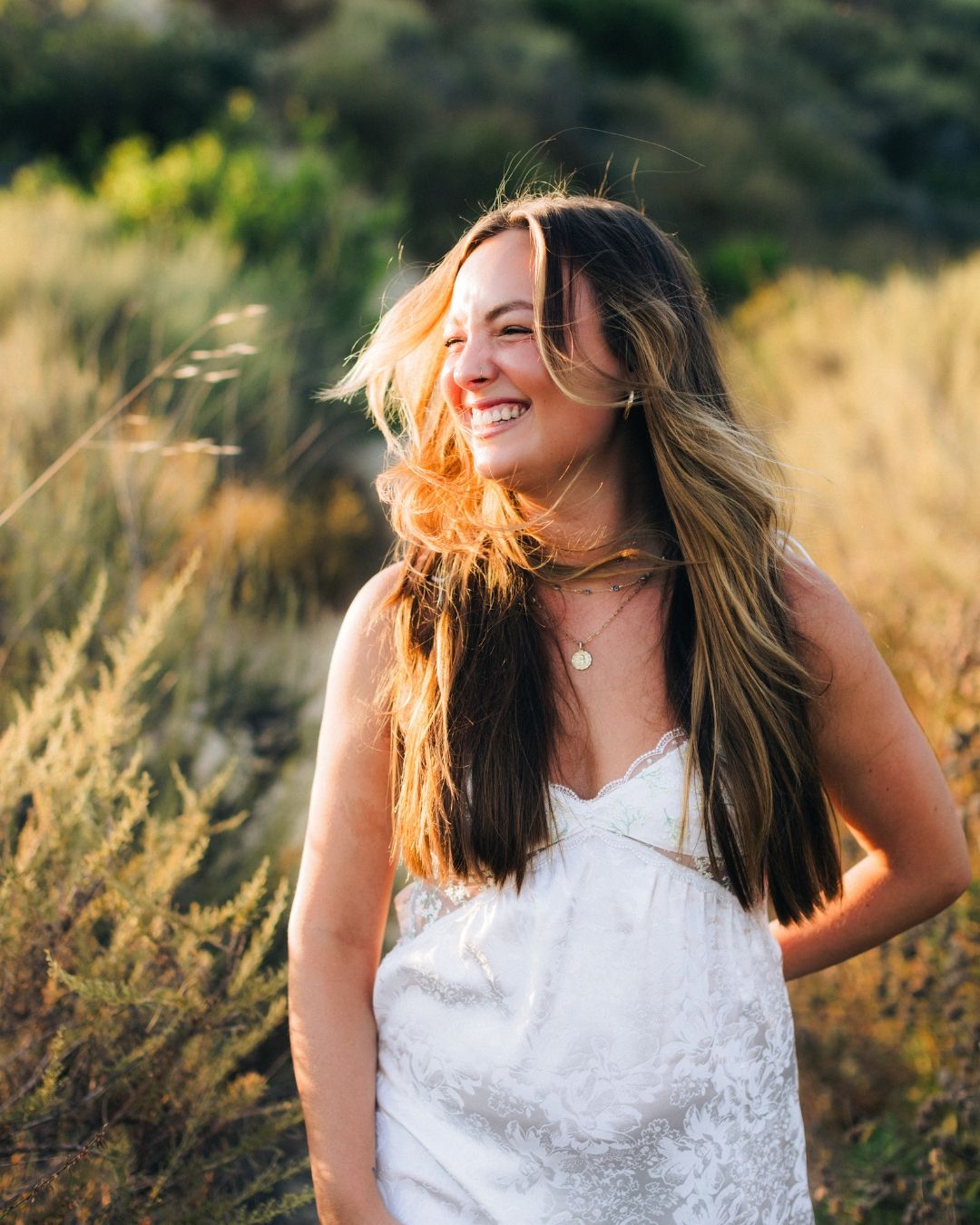 Woman in a white dress posing in a golden grass field, lifestyle portrait by Makenzie Rae Photography, Orange County California photographer