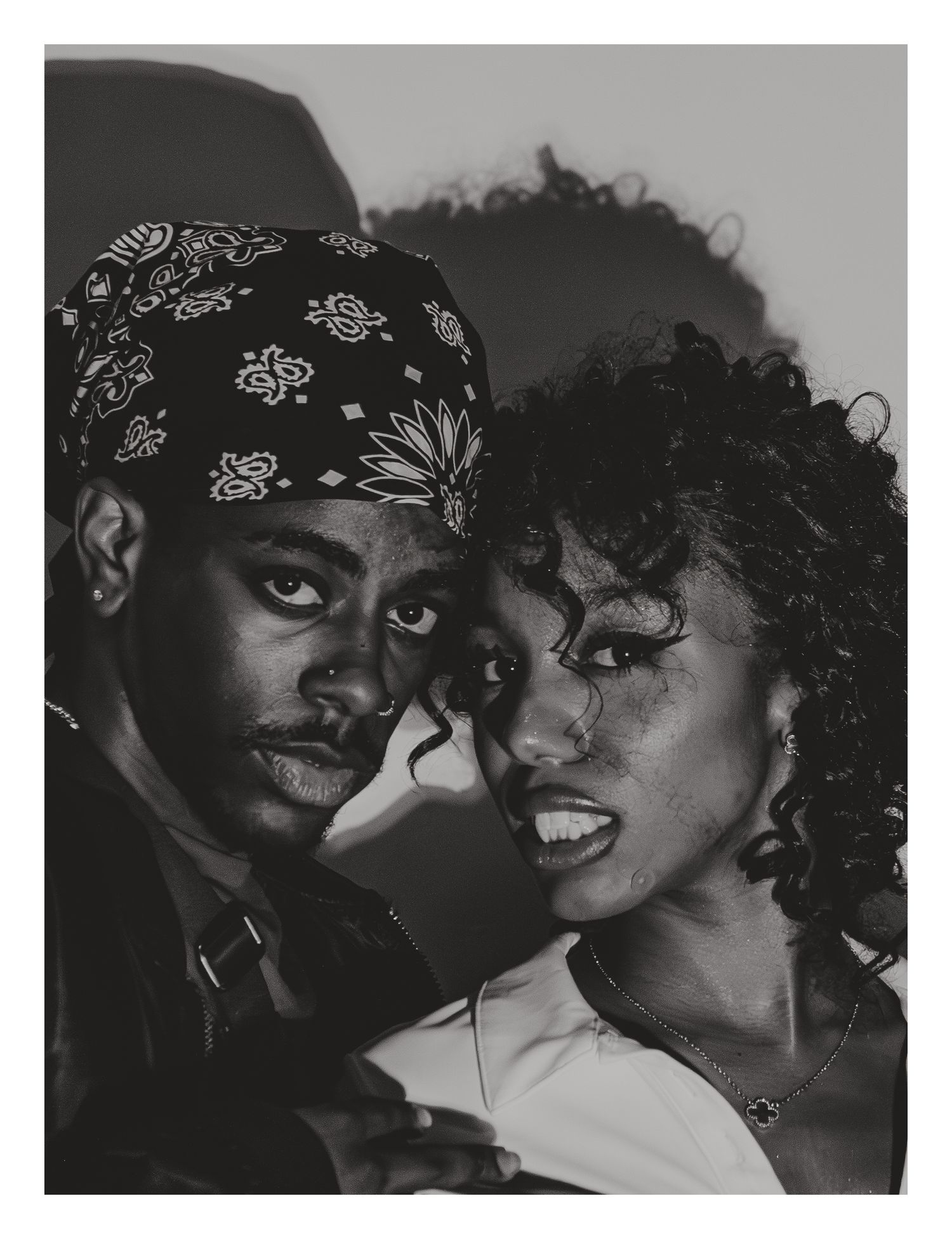 Black and white portrait of two people posing closely together in editorial style.