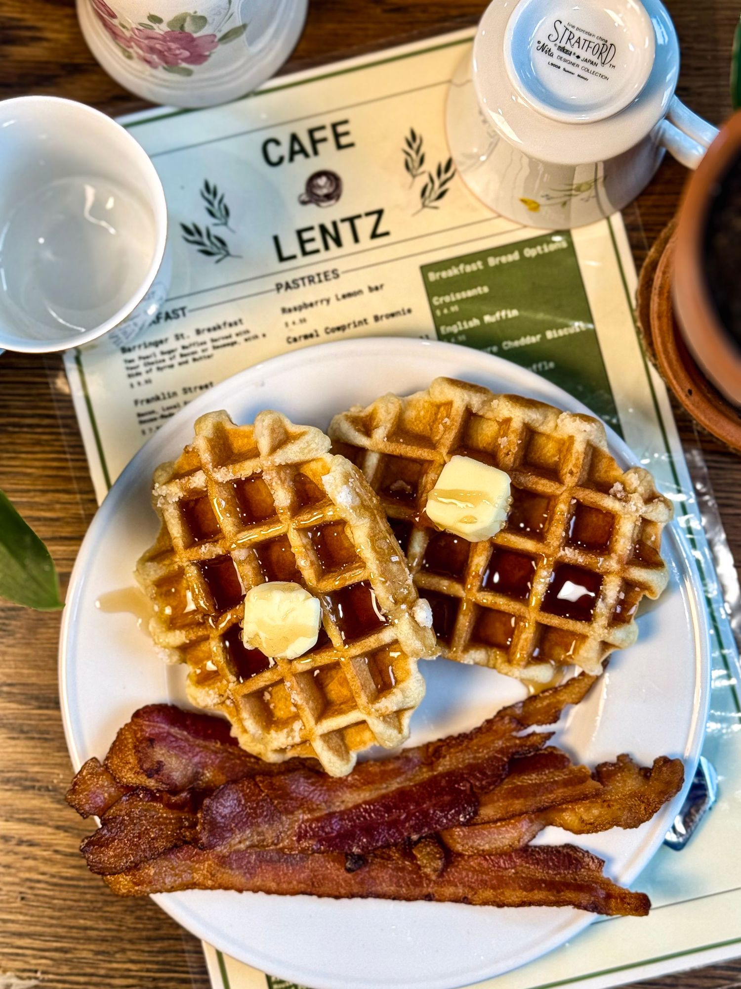 Classic Belgian waffles served with butter, syrup and crispy bacon strips at Cafe Lentz.